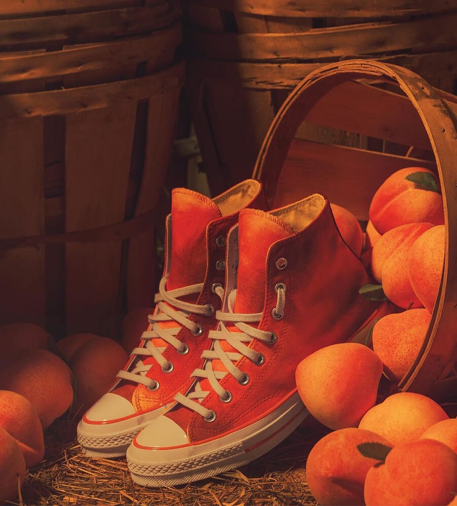 Person in blue denim jeans and orange converse all star high top