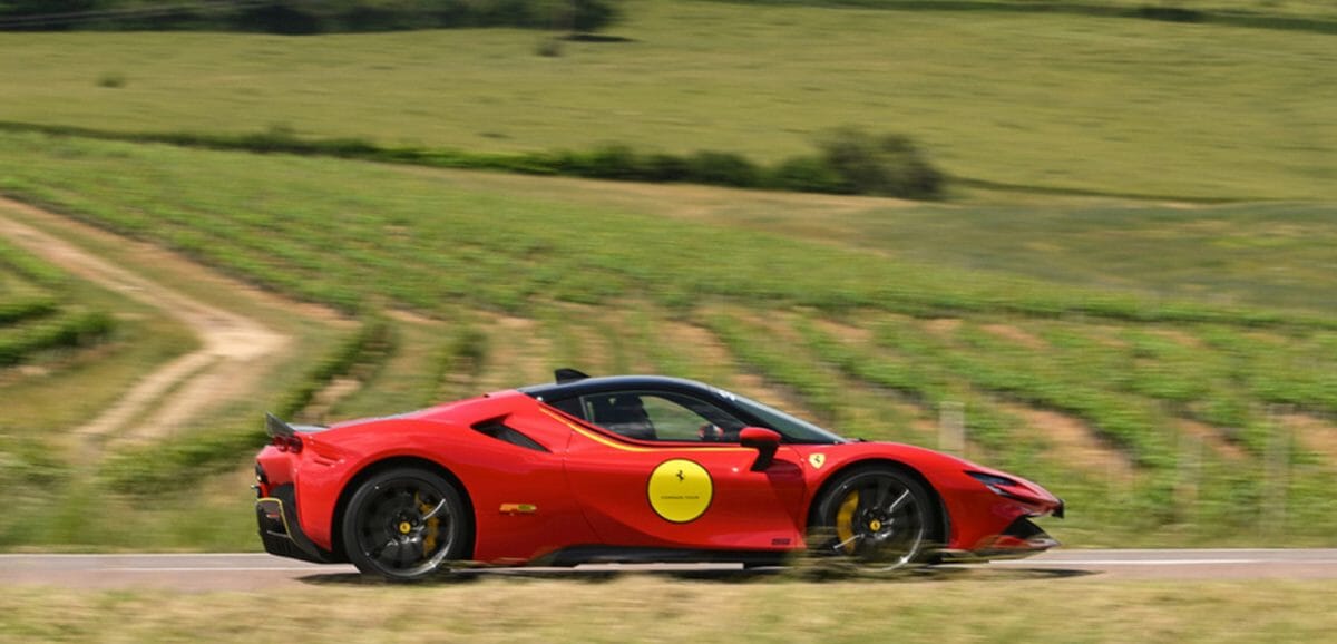 Red Ferrari Driving Through Fields