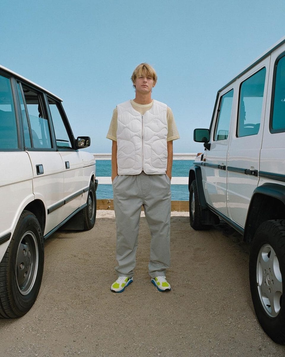 Stussy White Puffer Vest Gray Cargos Green and White Sneakers cars and beach